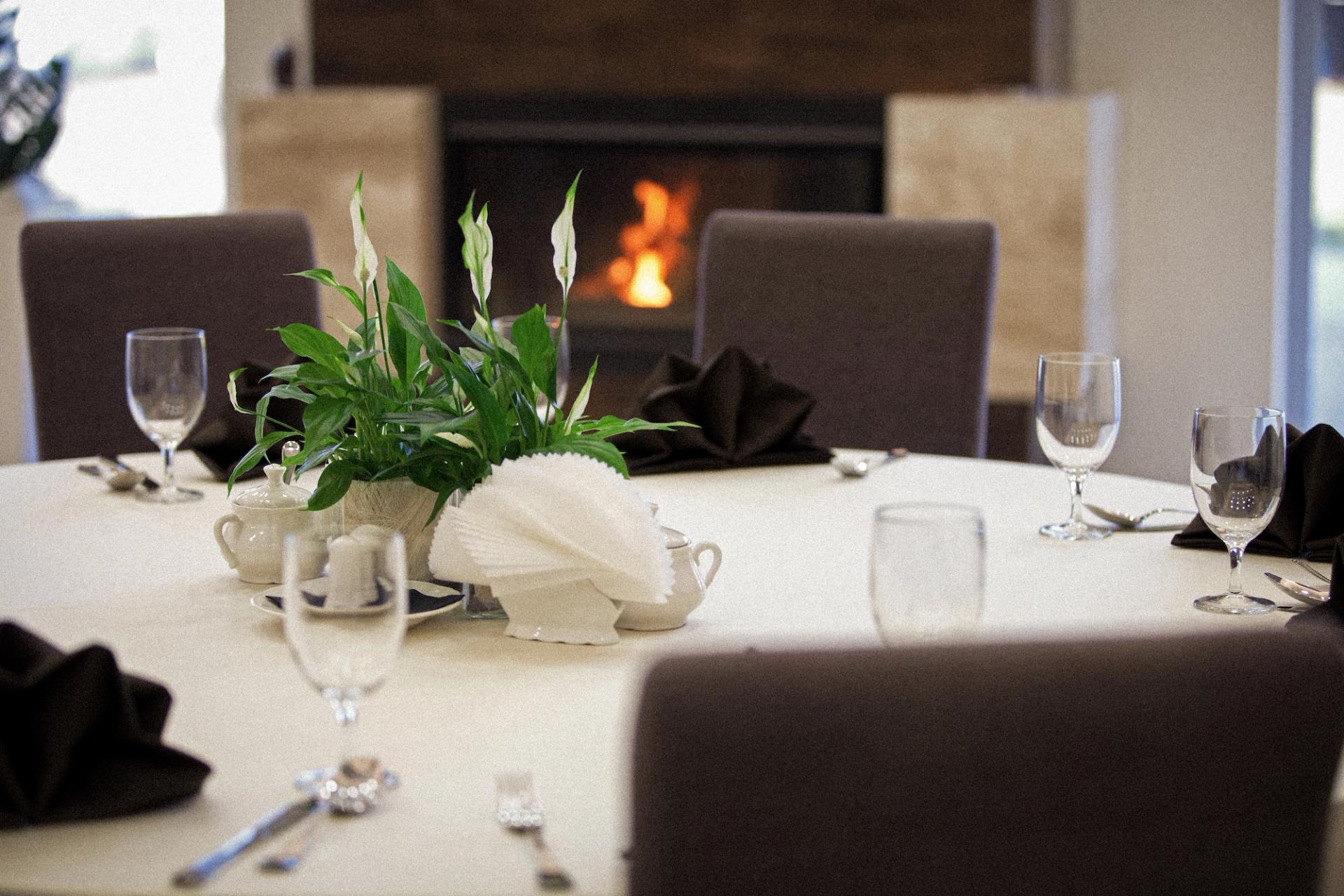 Set table with tableware, in the background a fireplace